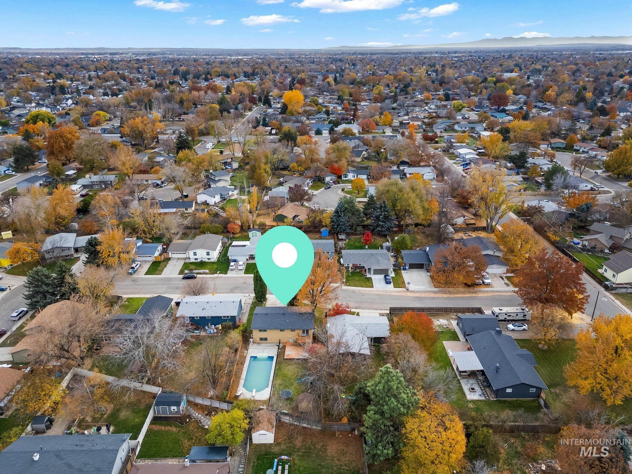 Aerial view of property and surrounding area featuring nearby suburban area