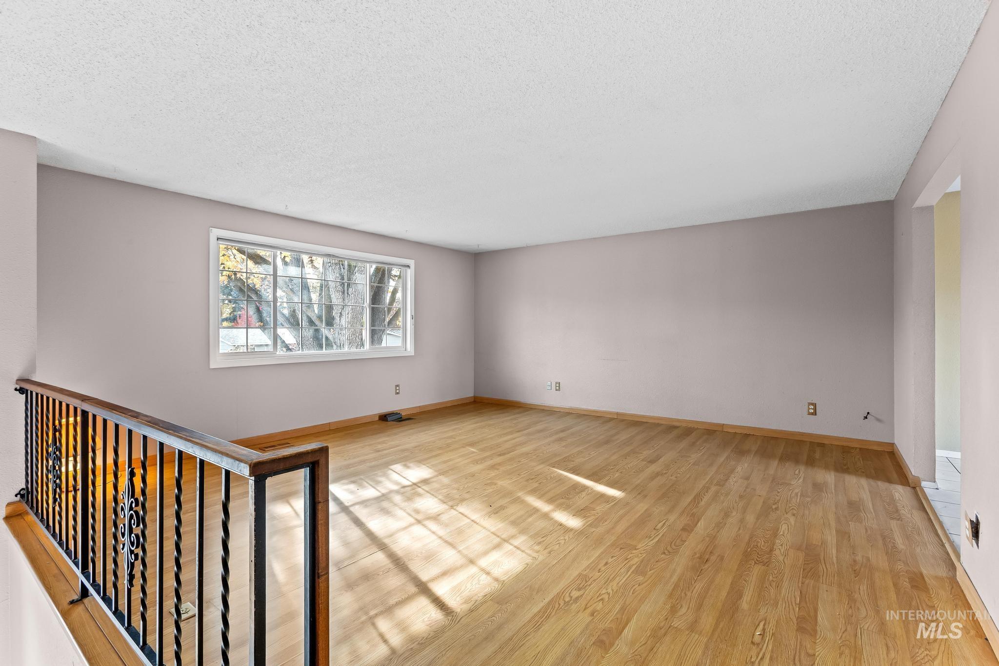 Spare room featuring light wood finished floors and a textured ceiling