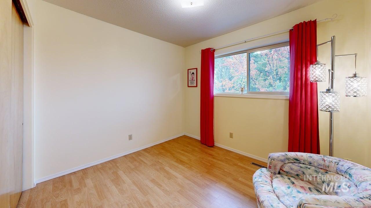 Sitting room featuring light wood-type flooring and a textured ceiling