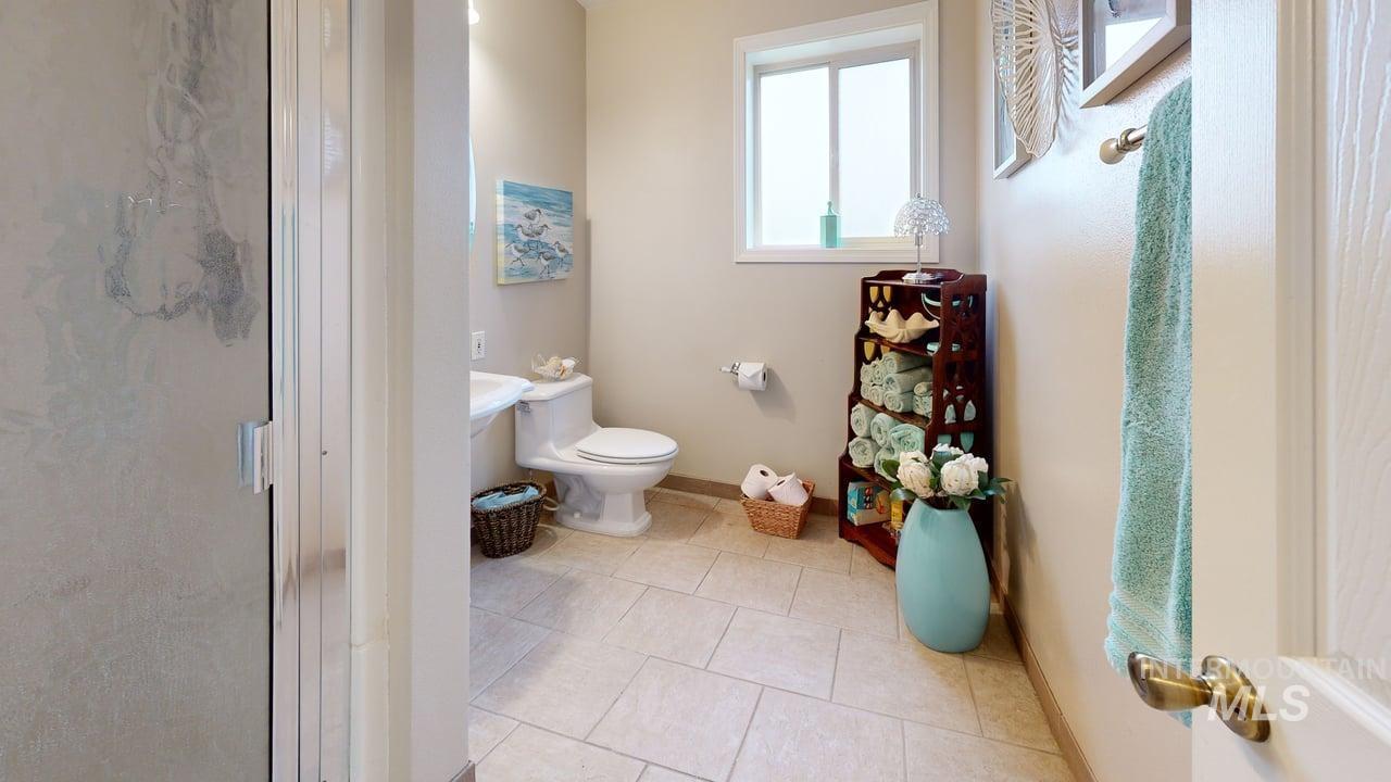Bathroom featuring a shower stall and light tile patterned flooring