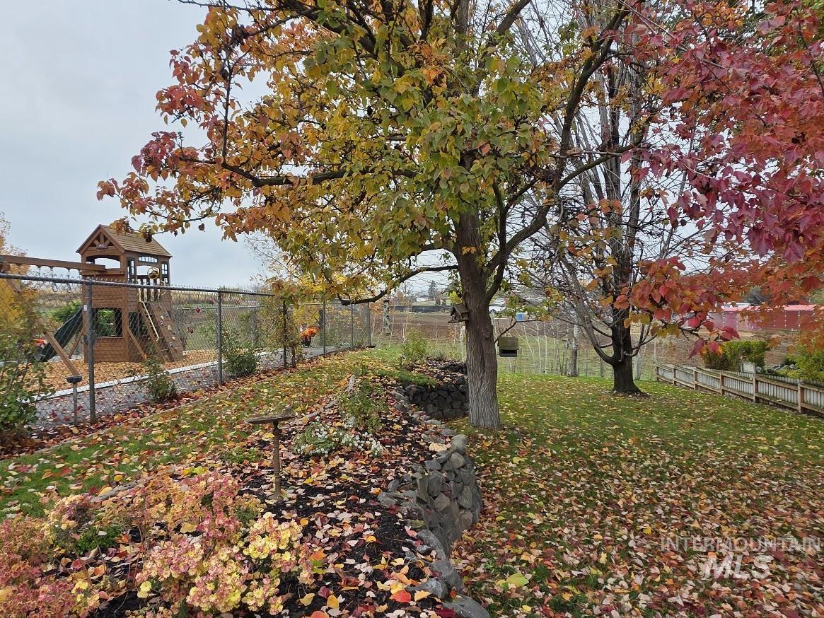 Fenced backyard featuring a playground
