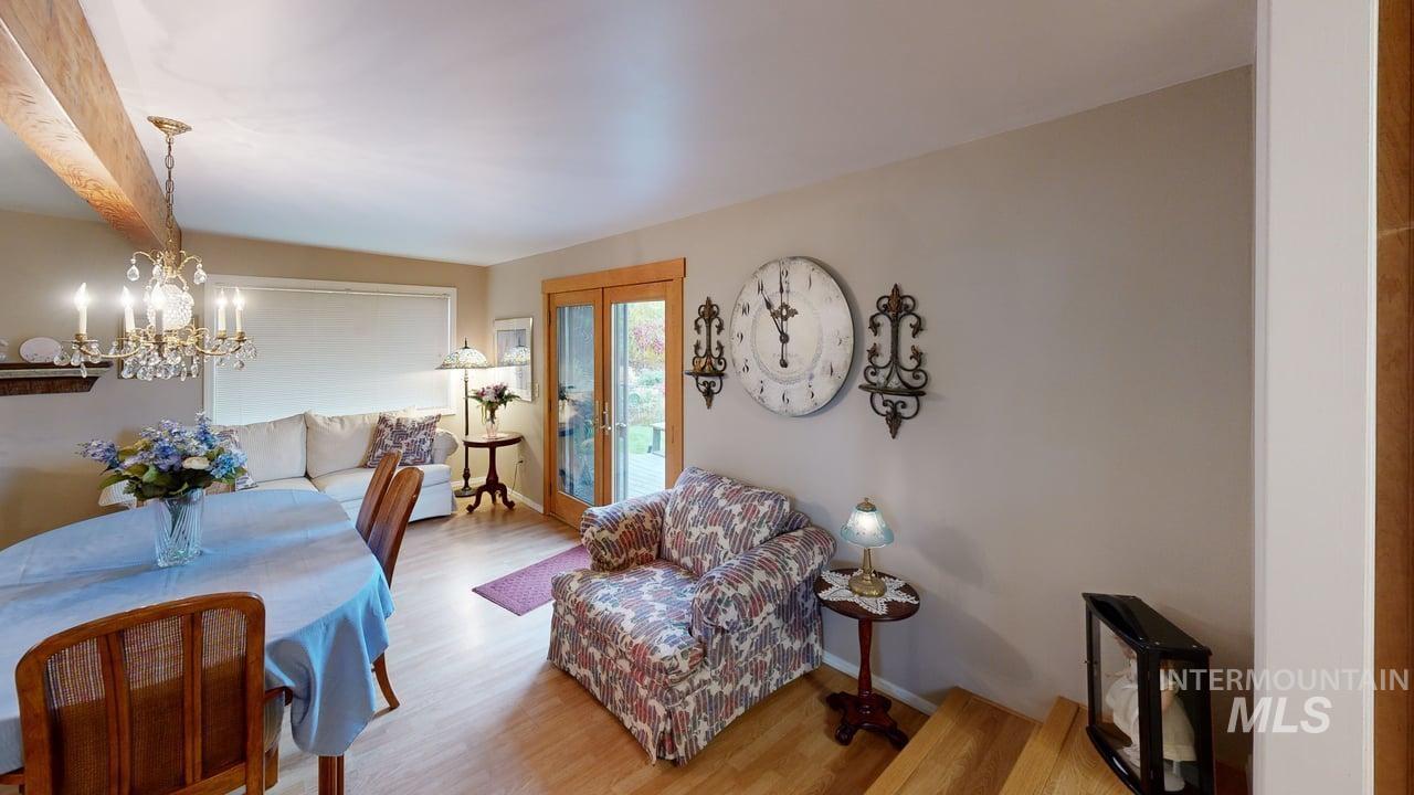 Living room featuring wood finished floors, a chandelier, and french doors
