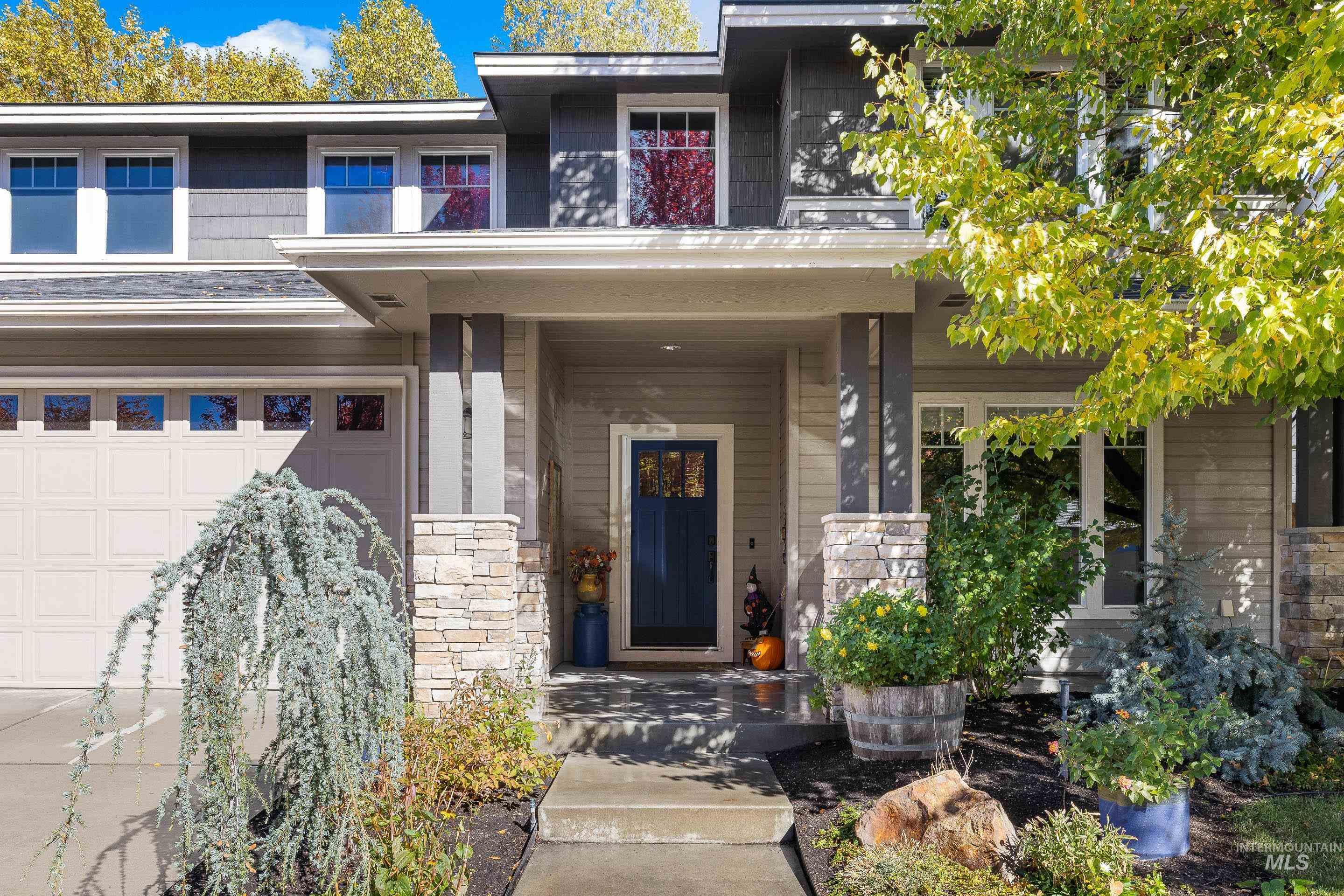 View of exterior entry featuring a porch, a garage, and stone siding