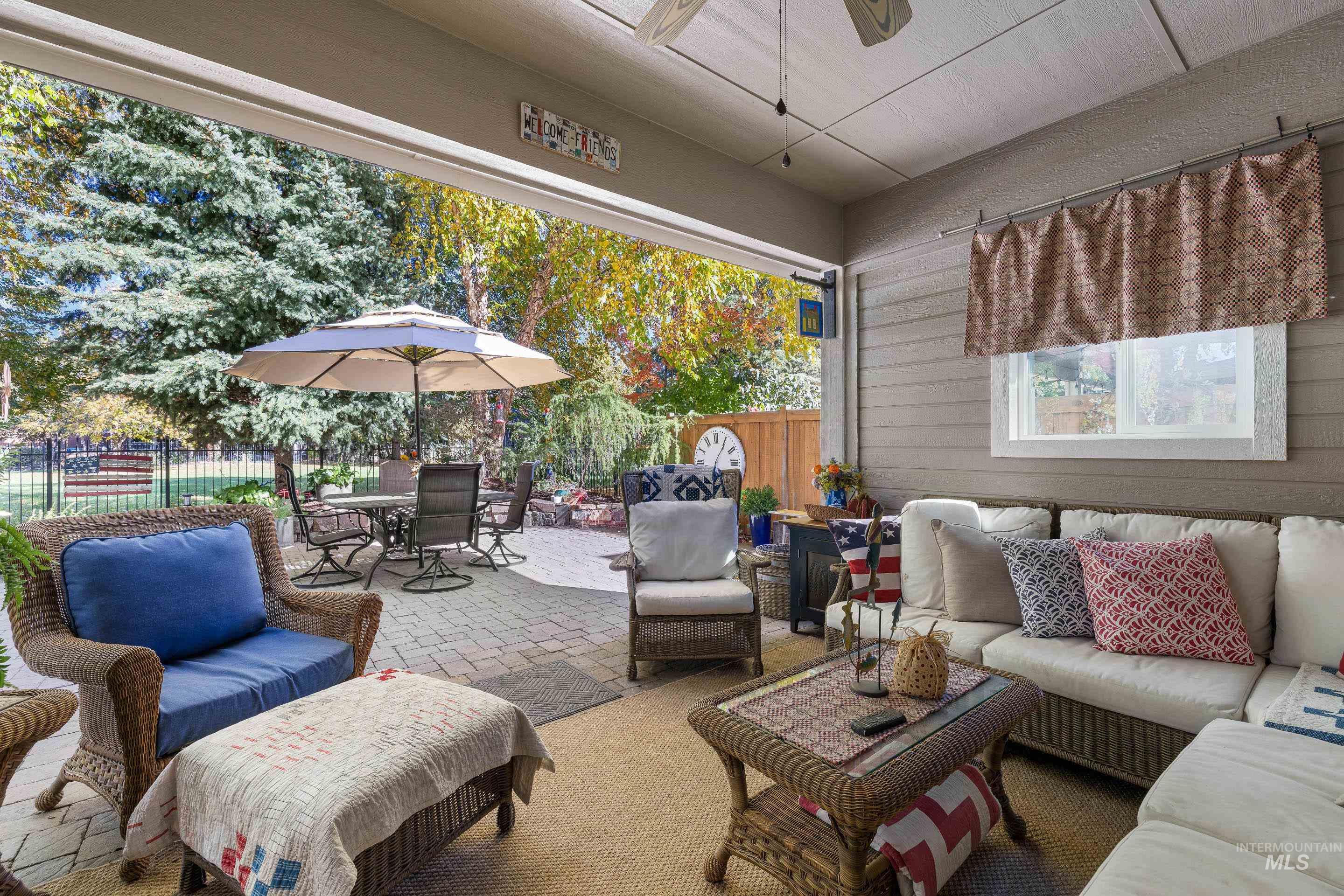 Fenced backyard with an outdoor hangout area, a patio, outdoor dining space, and a ceiling fan
