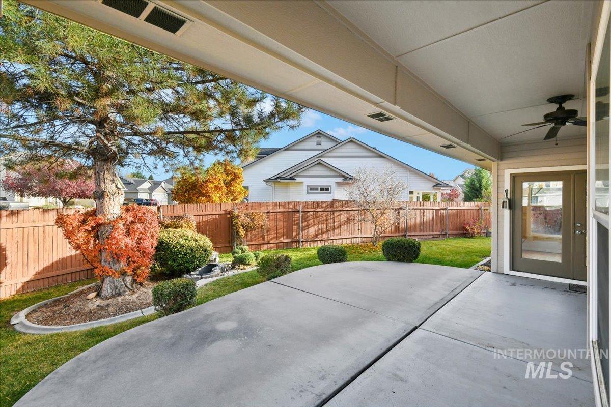 Fenced backyard featuring a patio and a ceiling fan