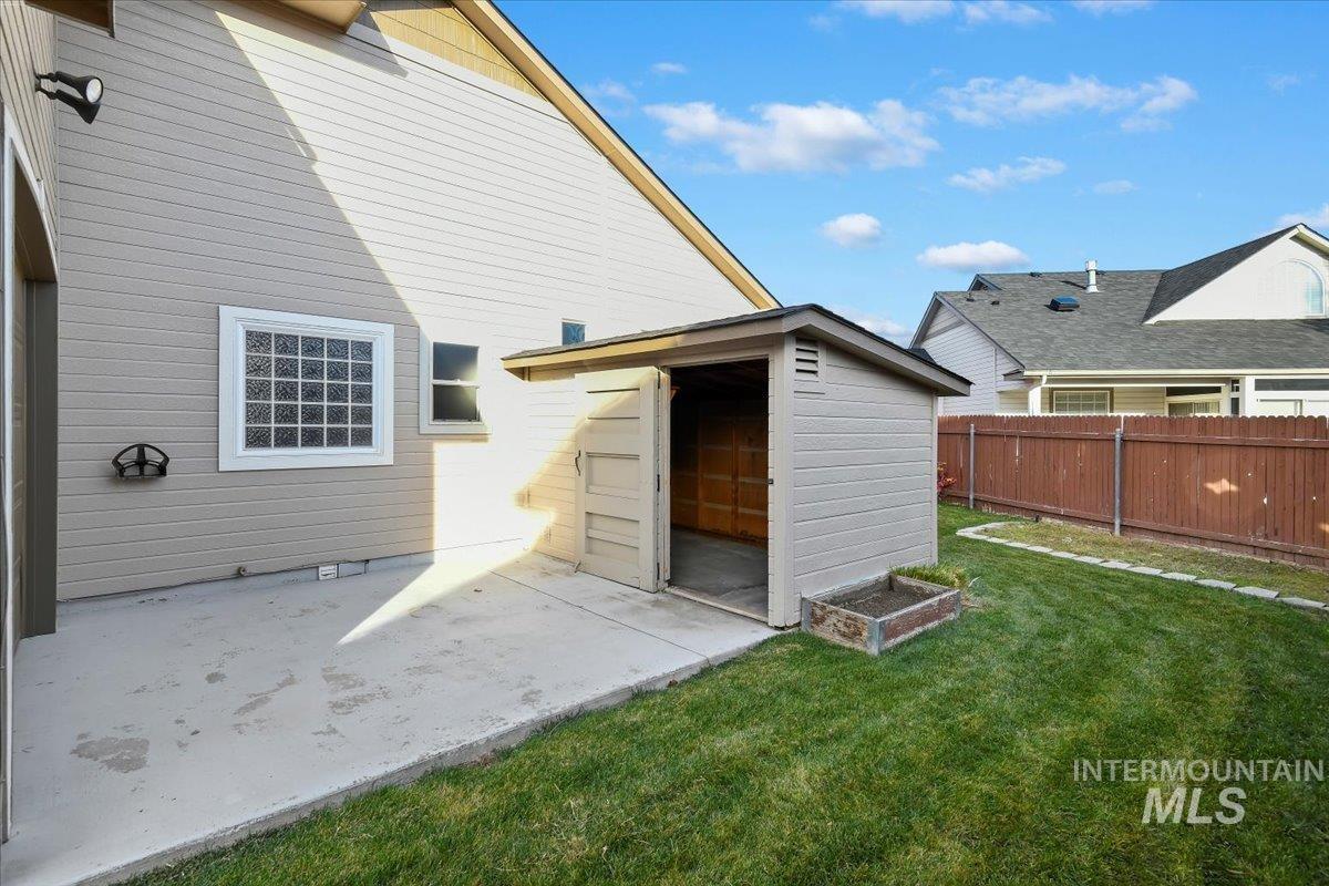 Back of property with a patio and a storage unit