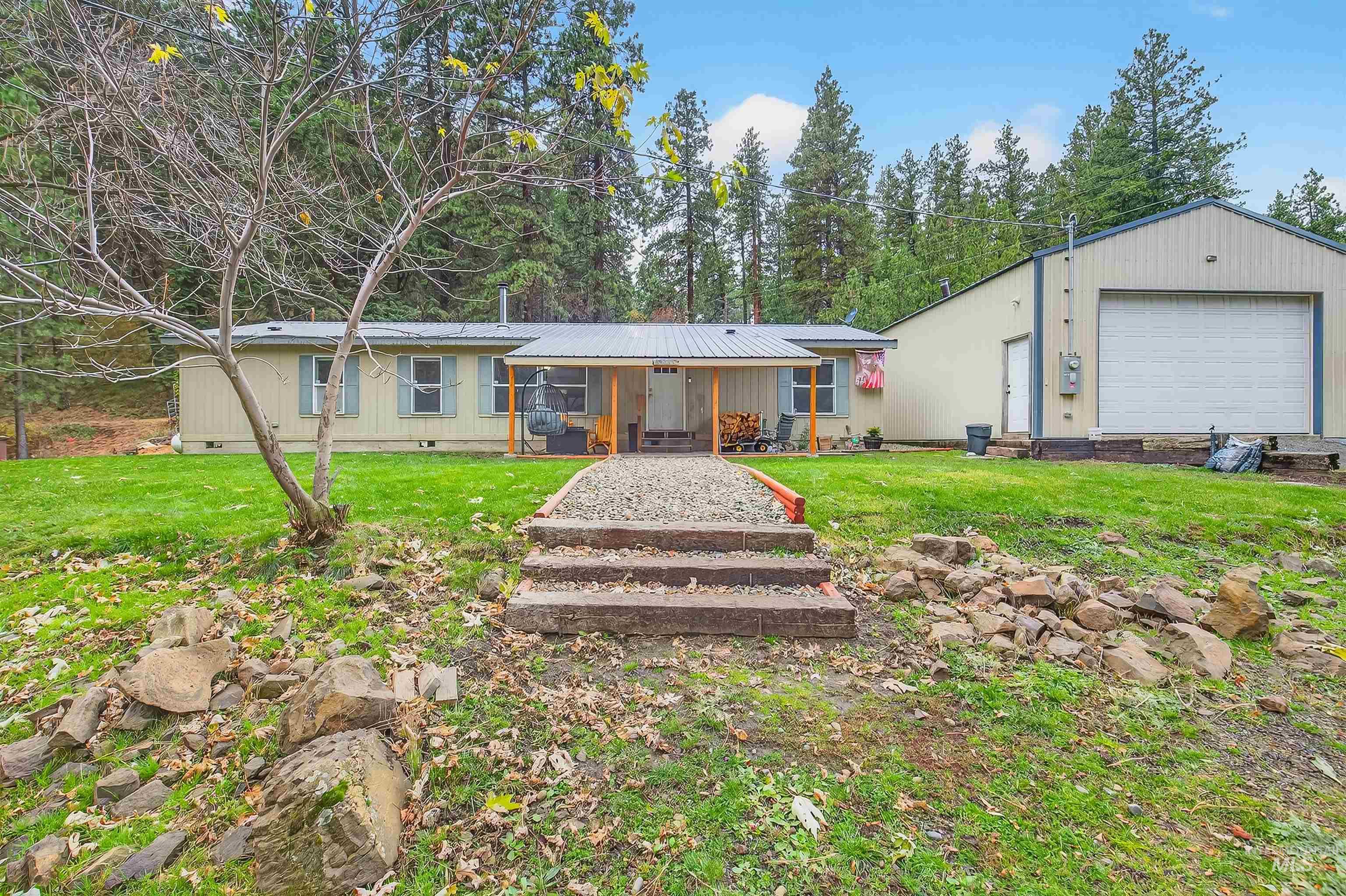 Single story home with a front lawn, crawl space, a garage, and a metal roof
