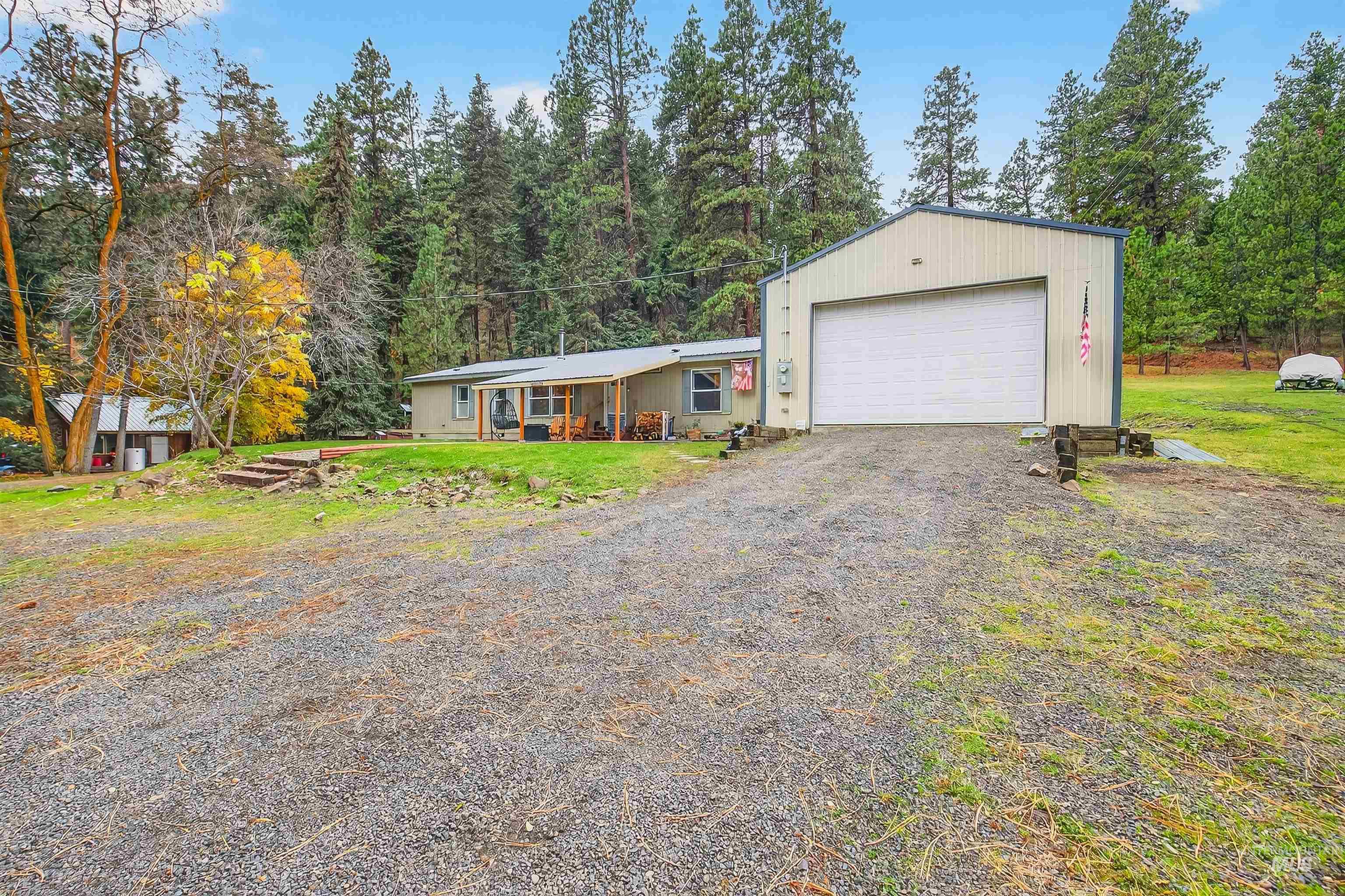 View of front of property featuring a garage, a front lawn, and driveway