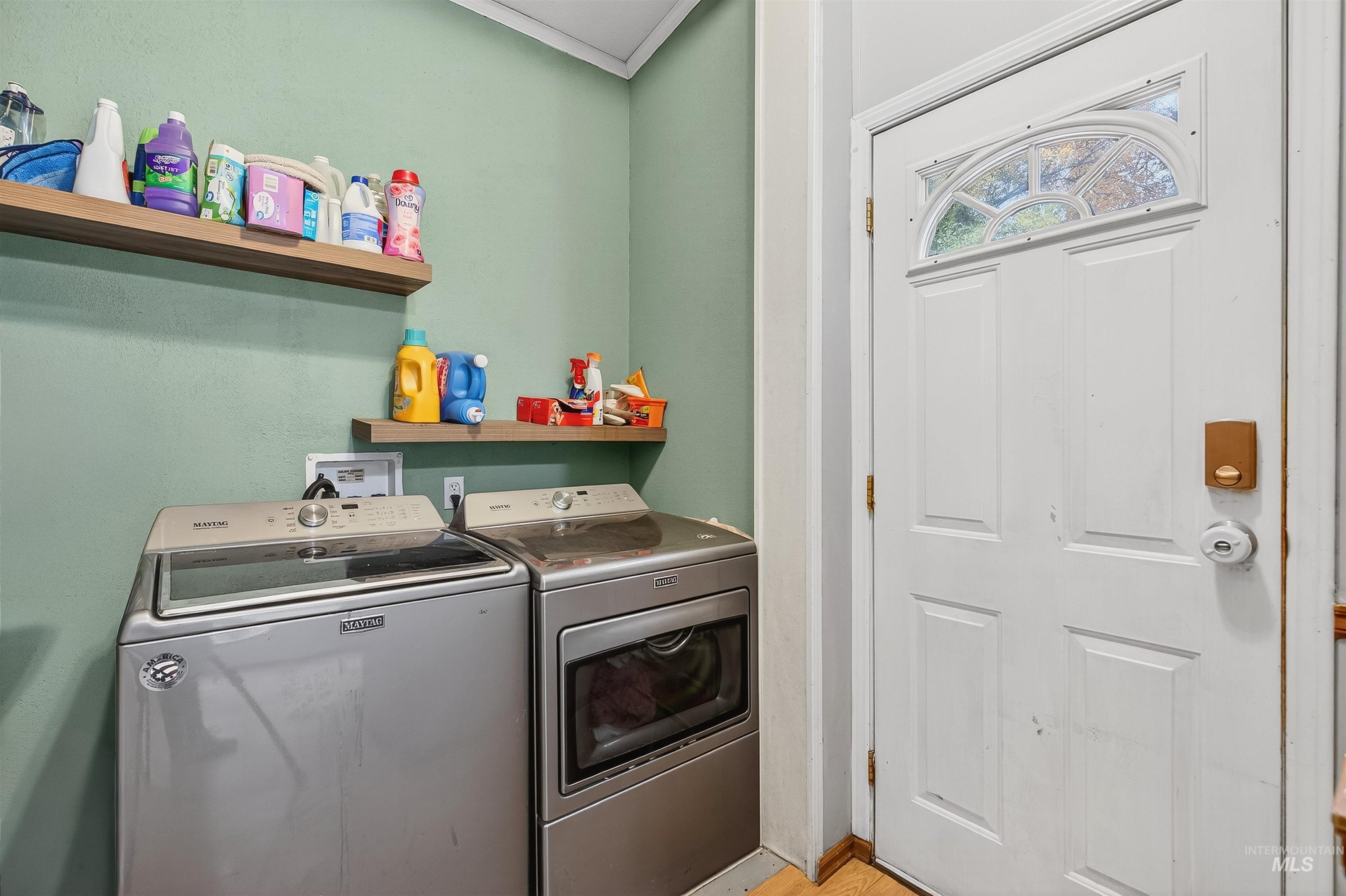 Laundry room featuring washing machine and clothes dryer and light wood-style flooring