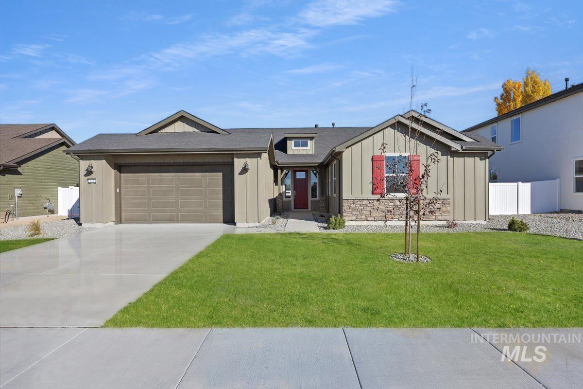 View of front facade with board and batten siding, concrete driveway, a garage, roof with shingles, and stone siding