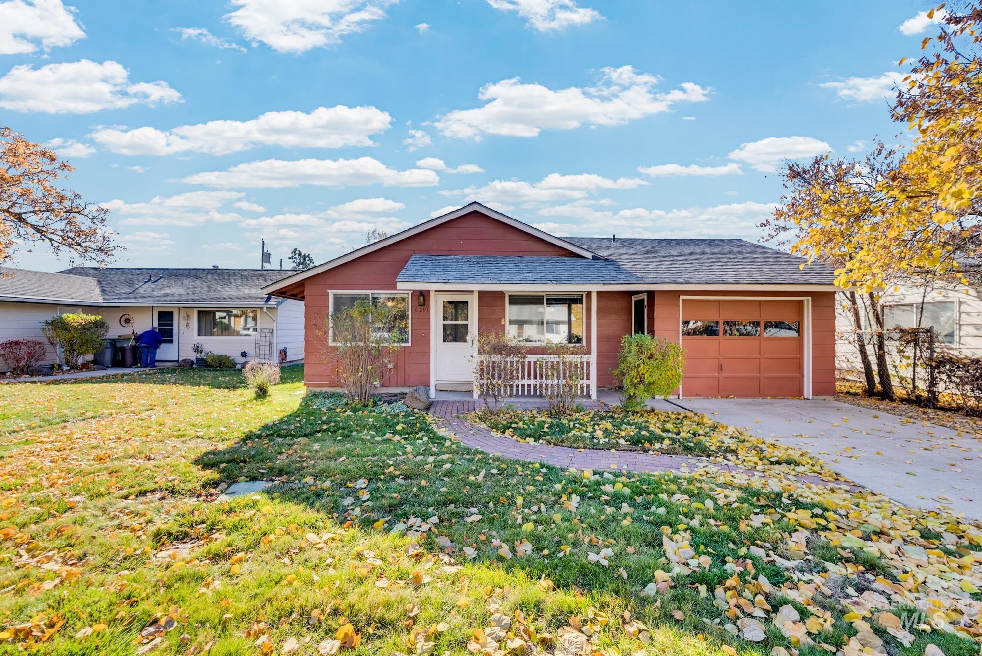 View of front of property featuring a garage, driveway, a porch, a front yard, and roof with shingles