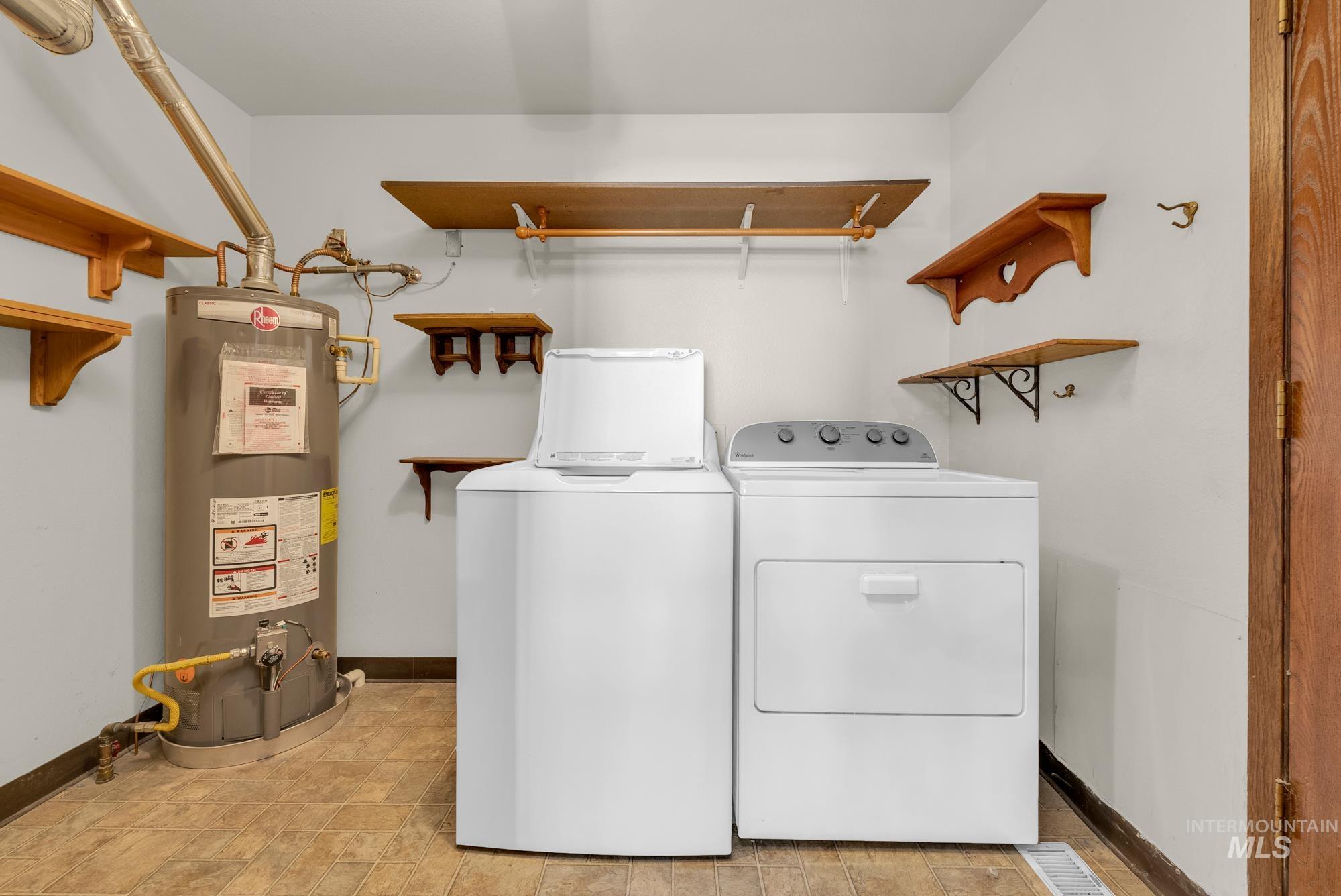 Laundry area featuring water heater and washing machine and clothes dryer