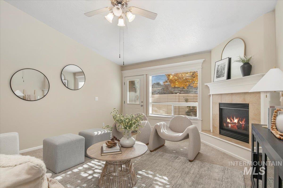 Living area with carpet floors and a tile fireplace