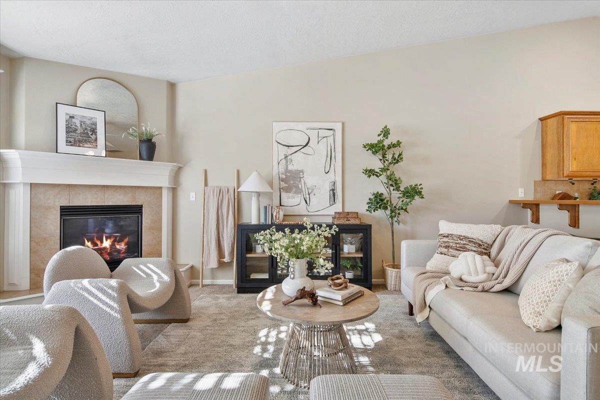 Carpeted living room with a fireplace and a textured ceiling