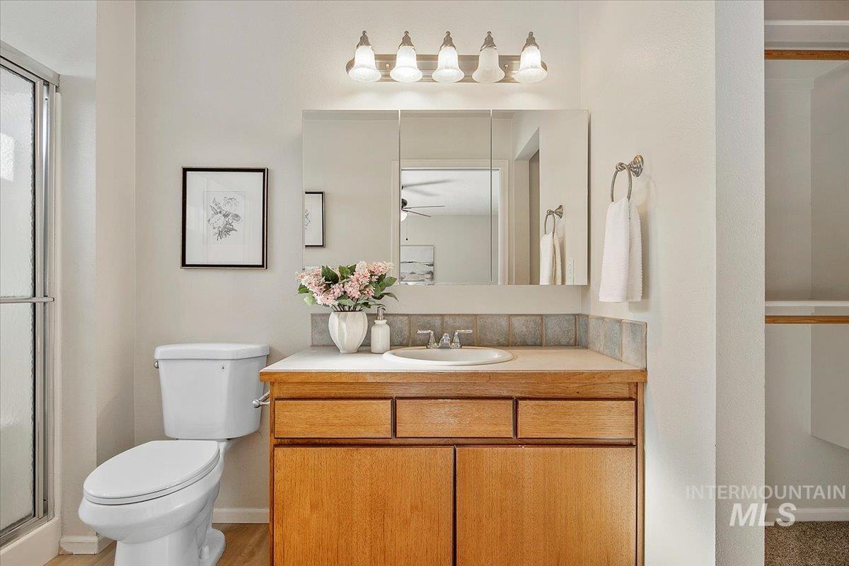 Full bath featuring a stall shower, vanity, and a ceiling fan