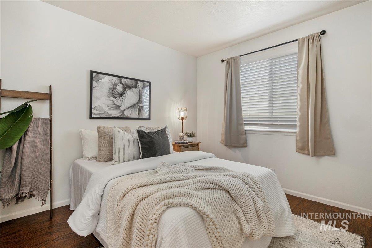 Bedroom with baseboards and dark wood-style flooring