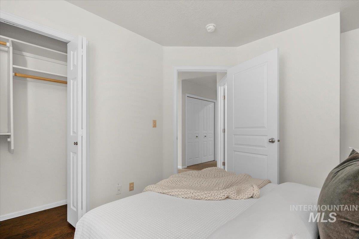 Bedroom with a closet and dark wood-style flooring
