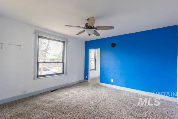 Unfurnished room featuring carpet floors and ceiling fan