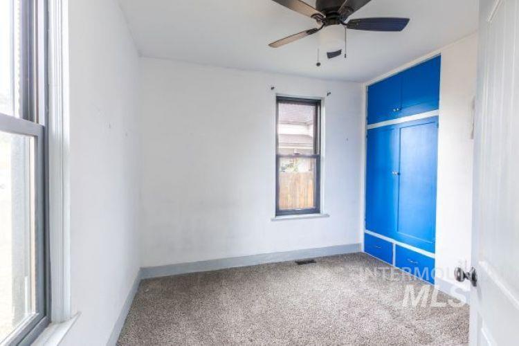 Carpeted spare room featuring baseboards and a ceiling fan