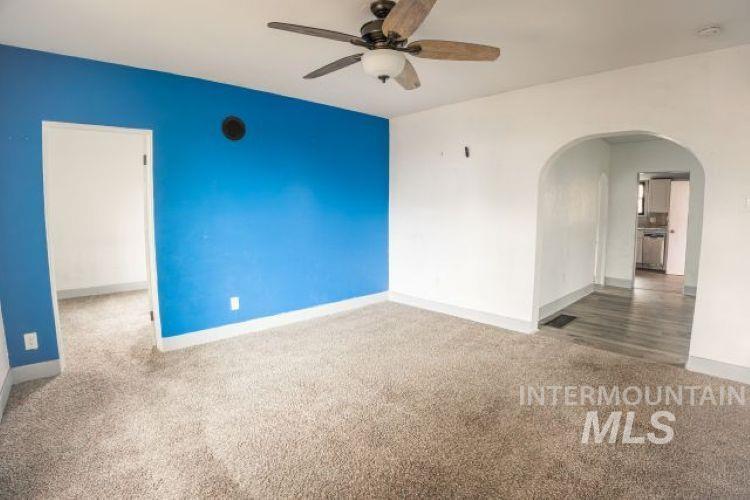 Spare room featuring carpet, ceiling fan, and arched walkways