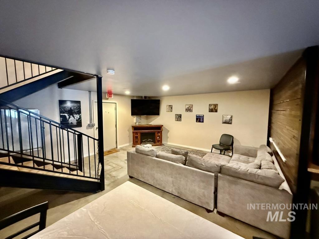 Living room featuring a fireplace, stairway, and recessed lighting
