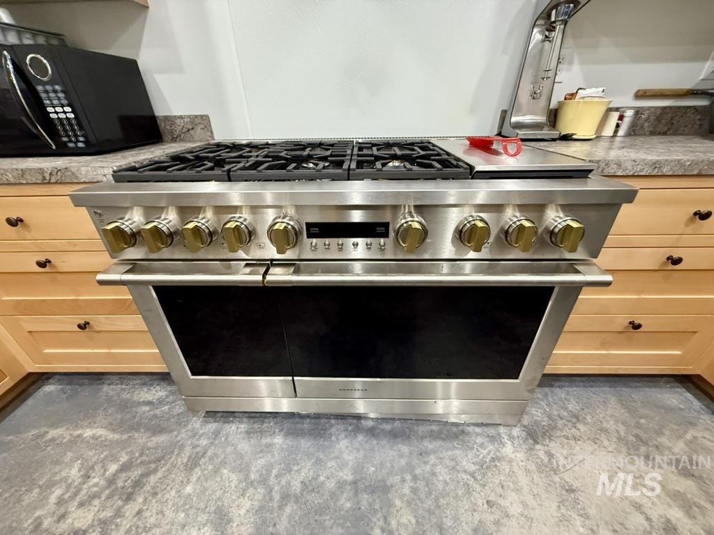 Kitchen view of light brown cabinetry and range with two ovens