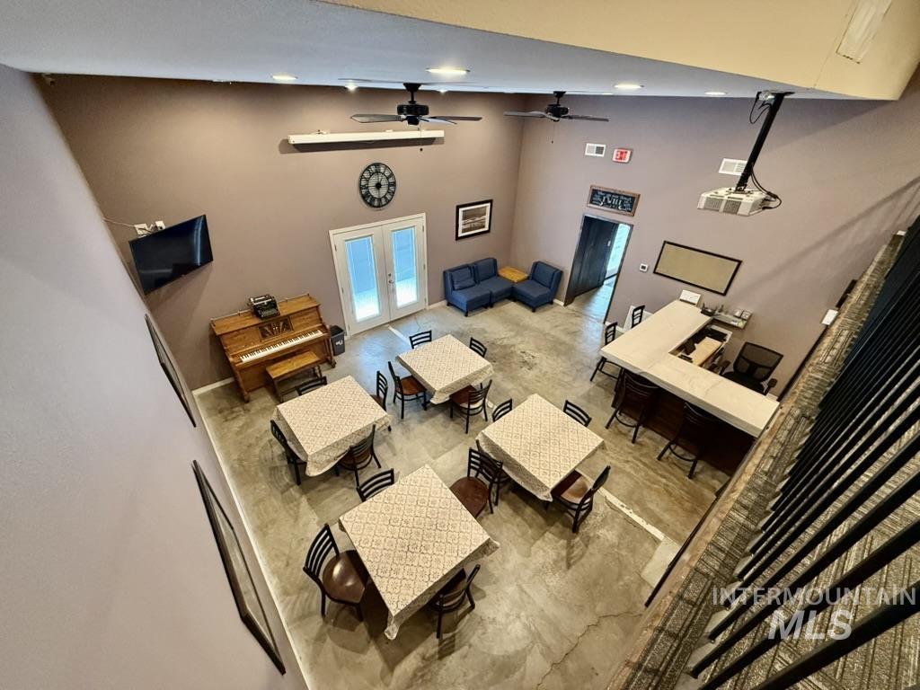 Living area featuring a towering ceiling, french doors, and ceiling fan