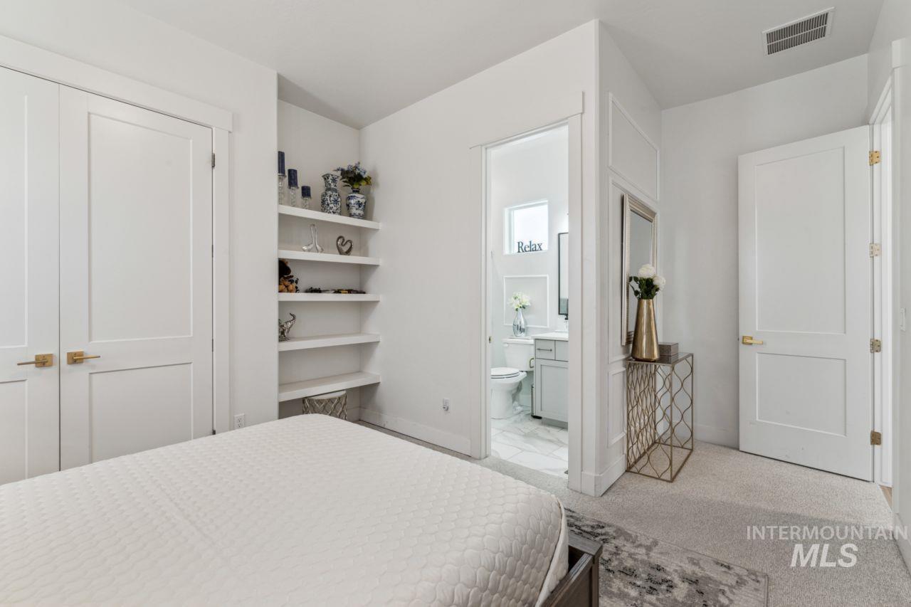 Bedroom with carpet floors and connected bathroom