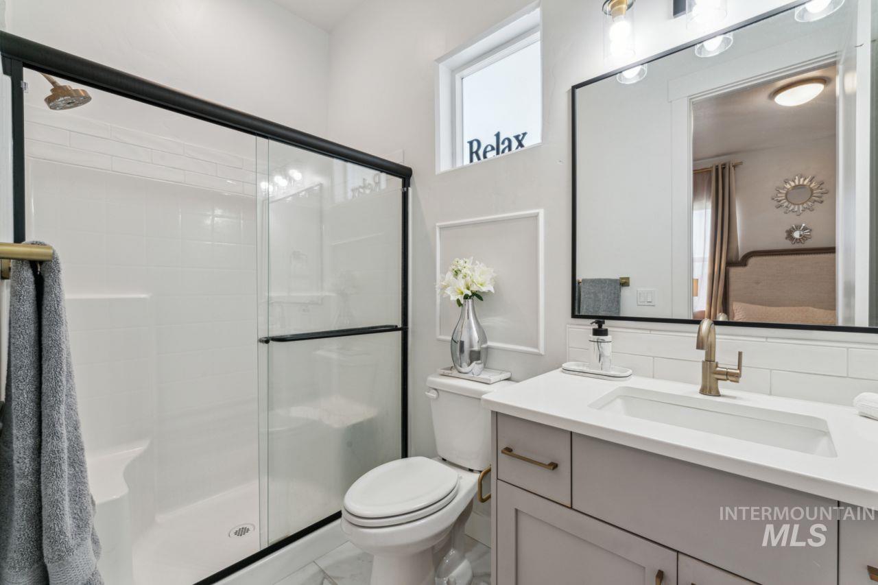 Bathroom featuring a shower stall and vanity