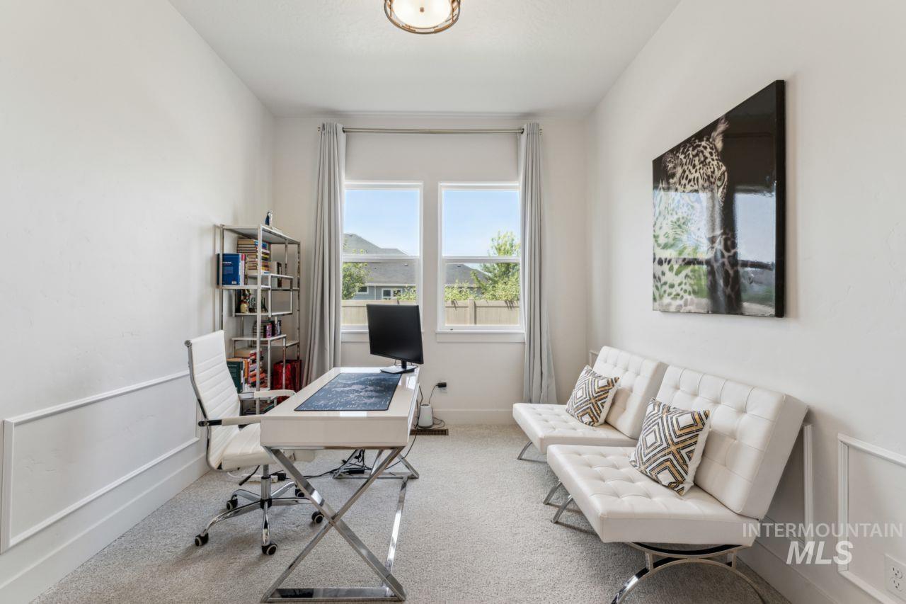 Carpeted home office featuring baseboards