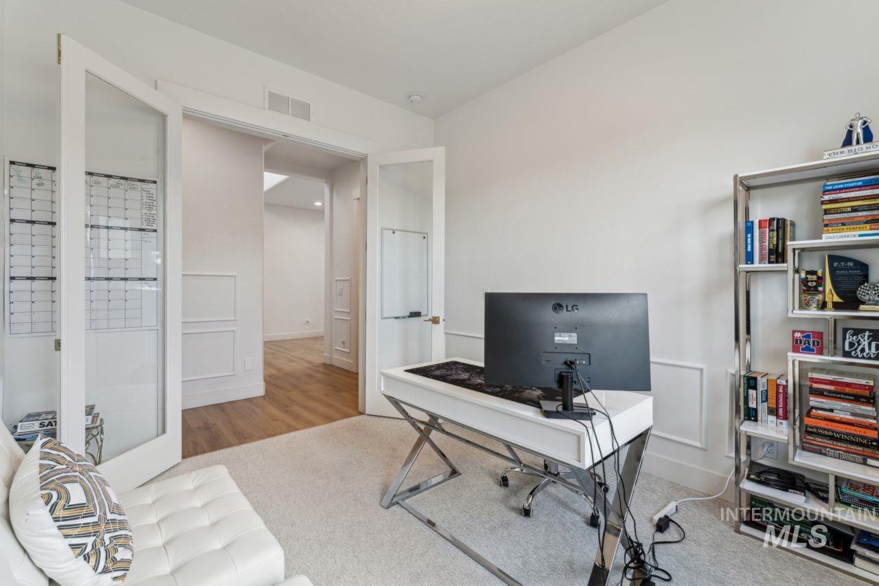 Office area featuring carpet floors, french doors, and wood finished floors