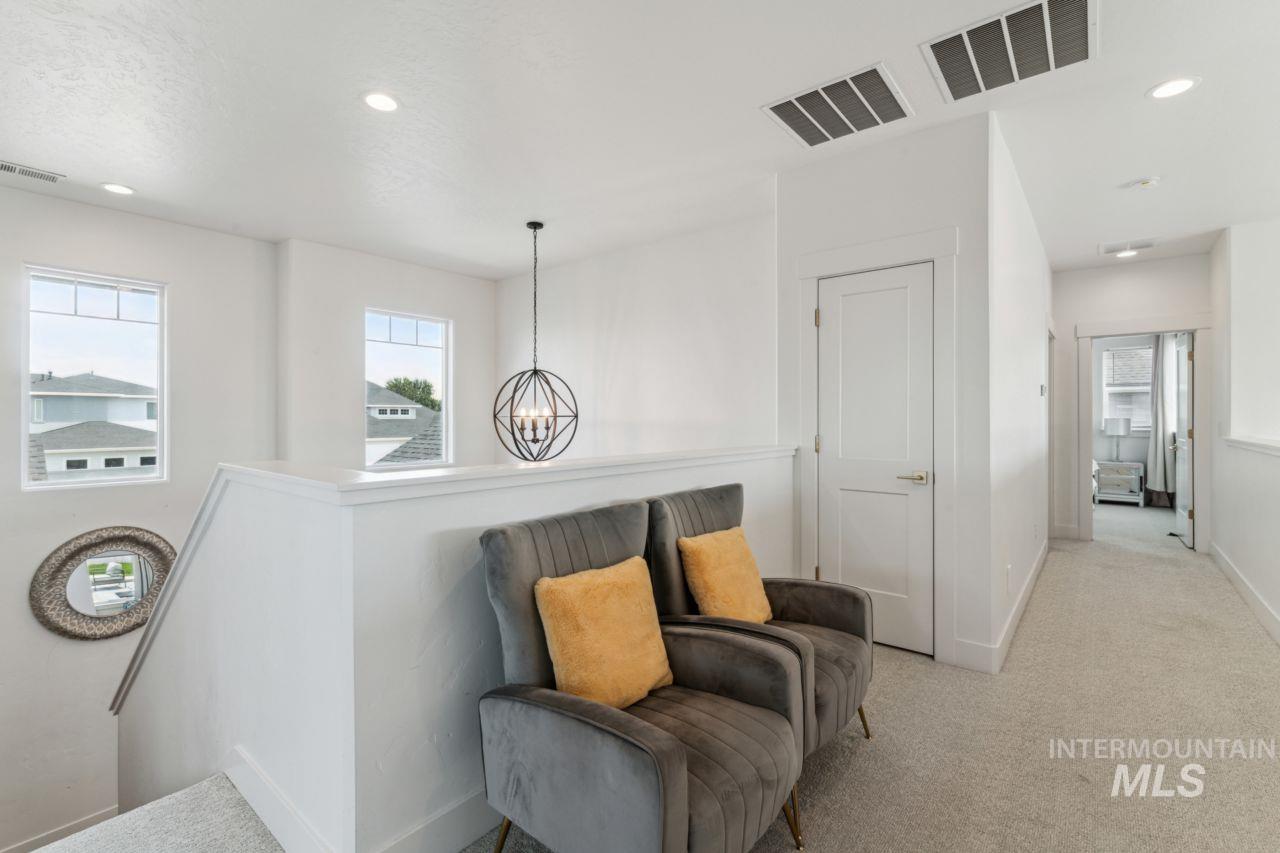 Sitting room with recessed lighting, light carpet, an upstairs landing, a chandelier, and a textured ceiling