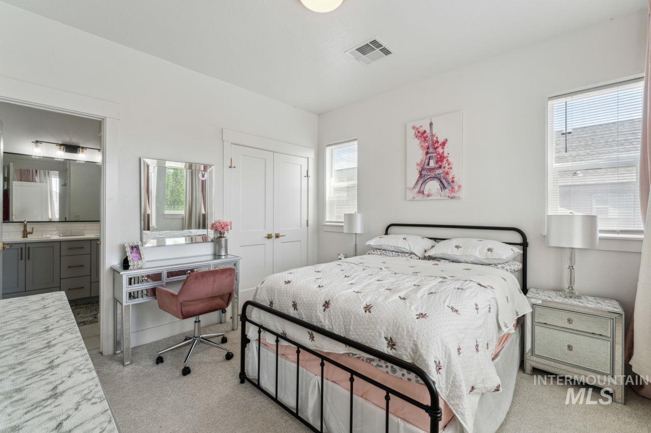 Bedroom with multiple windows, carpet floors, a closet, and ensuite bathroom