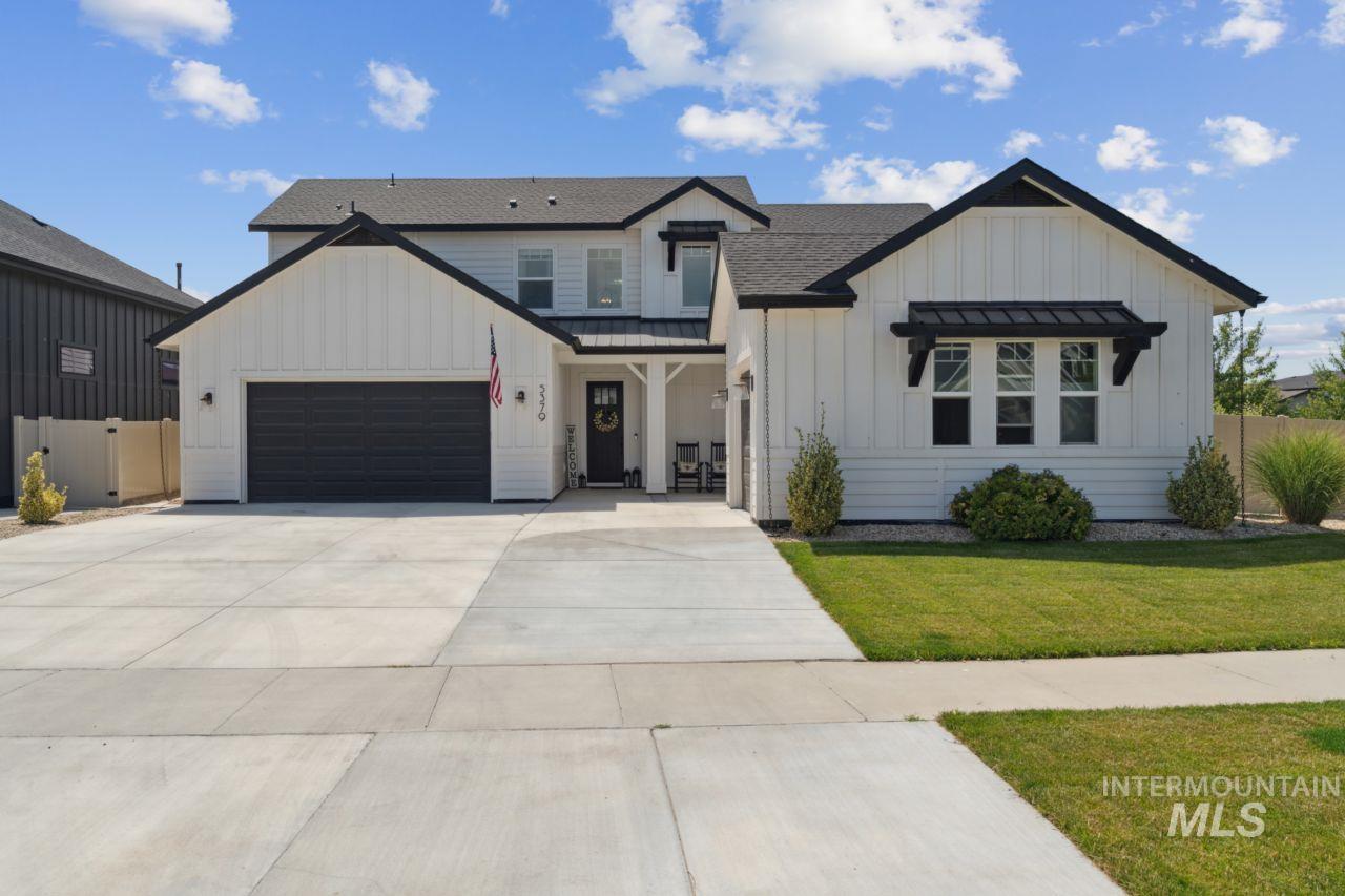 Modern inspired farmhouse with board and batten siding, driveway, an attached garage, and a shingled roof