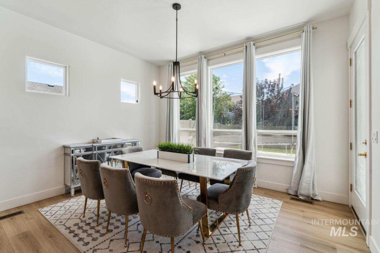 Dining room with light wood-type flooring and a chandelier