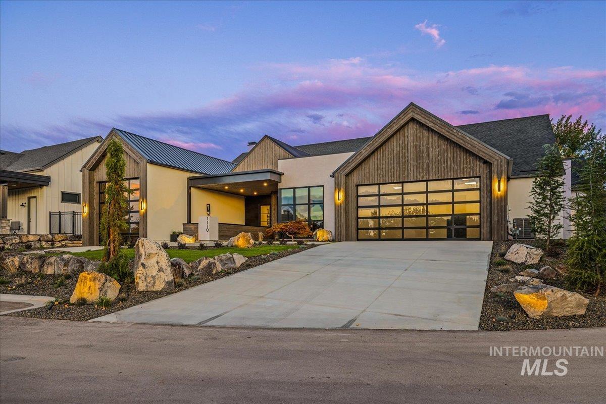 View of front of home featuring concrete driveway, a garage, a metal roof, and a standing seam roof