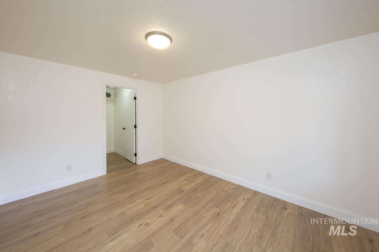 Unfurnished room with light wood-style flooring and baseboards