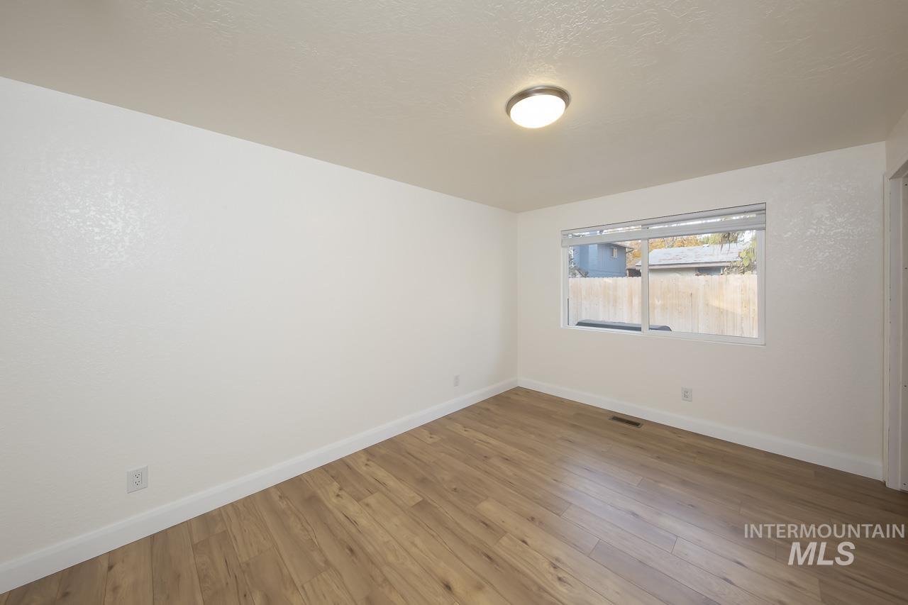 Unfurnished room featuring wood finished floors and a textured ceiling
