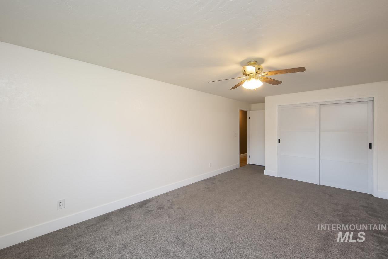 Unfurnished bedroom with carpet, a closet, and a ceiling fan