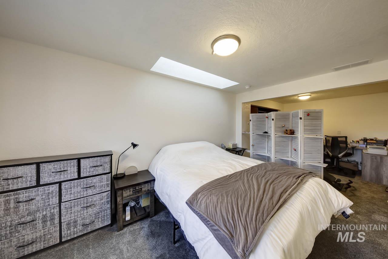 Bedroom featuring carpet floors, a skylight, and a textured ceiling