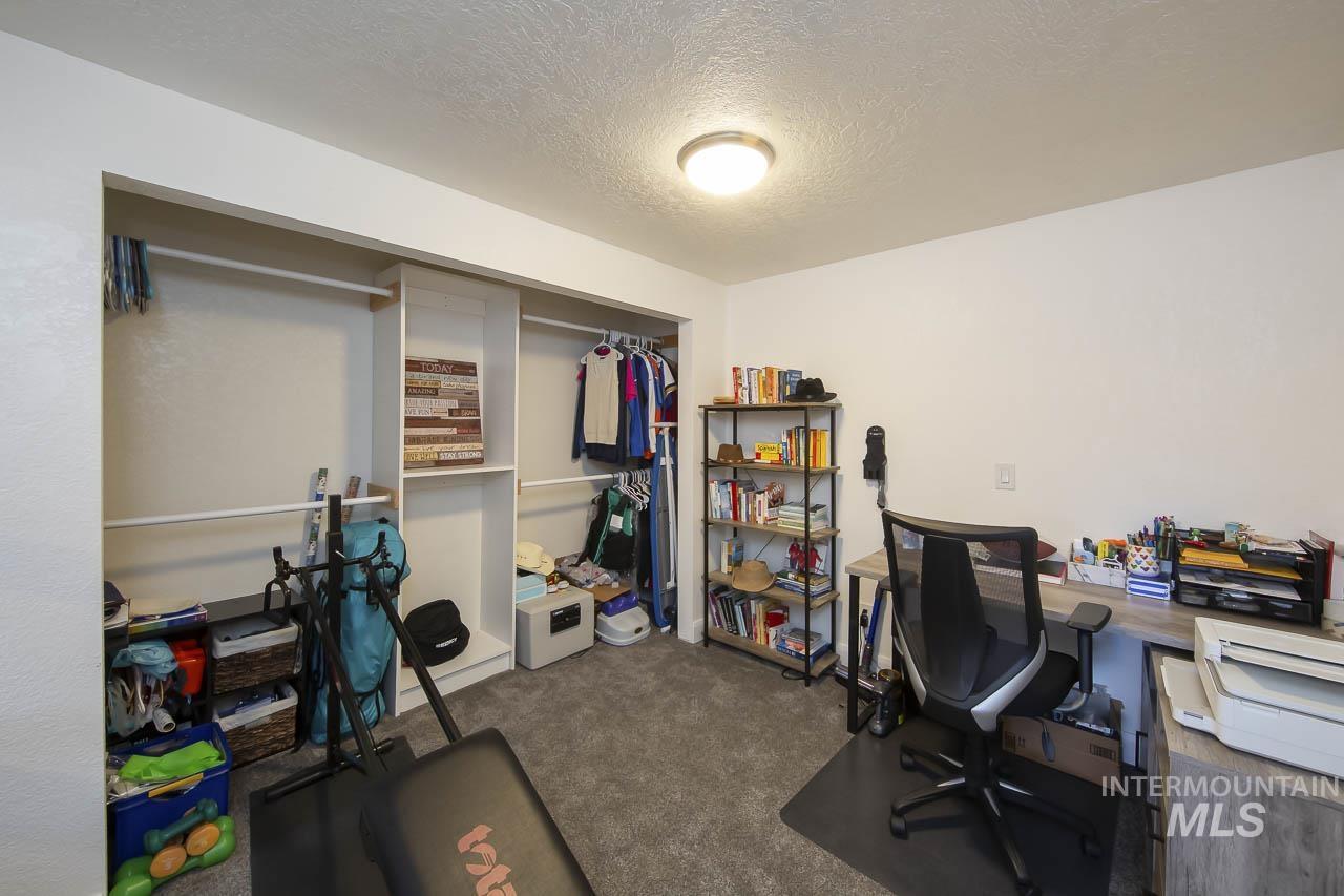 Office area featuring a textured ceiling and dark carpet