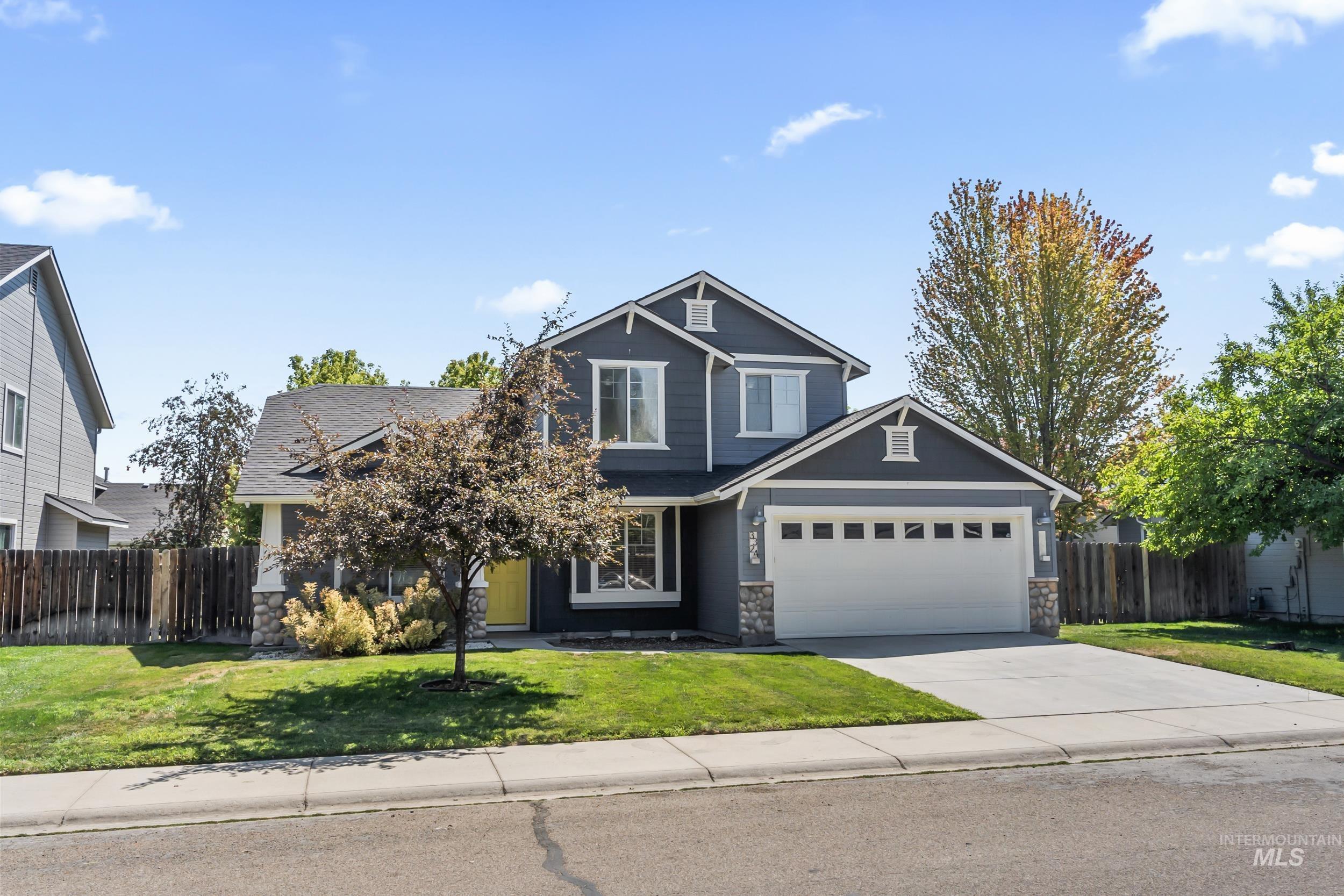 Craftsman-style home featuring stone siding, concrete driveway, and an attached garage