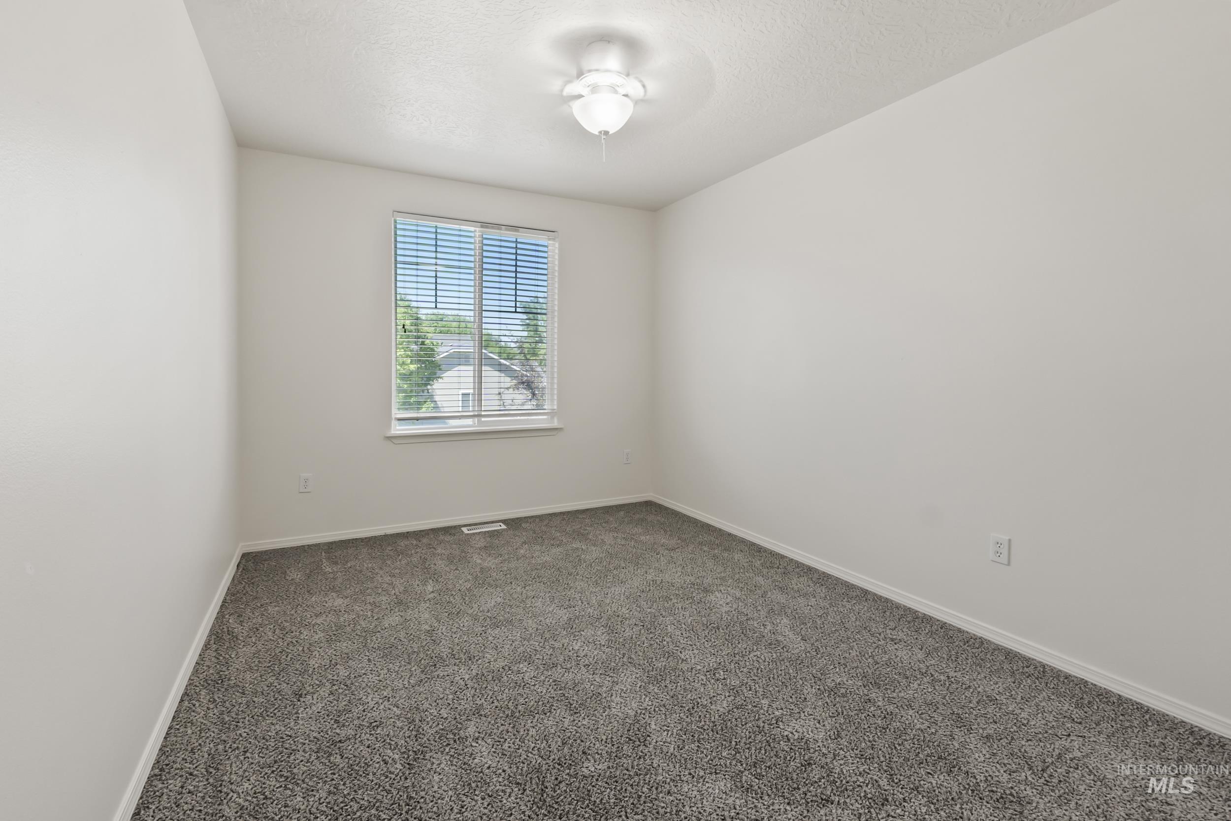 Unfurnished room with carpet flooring and a textured ceiling
