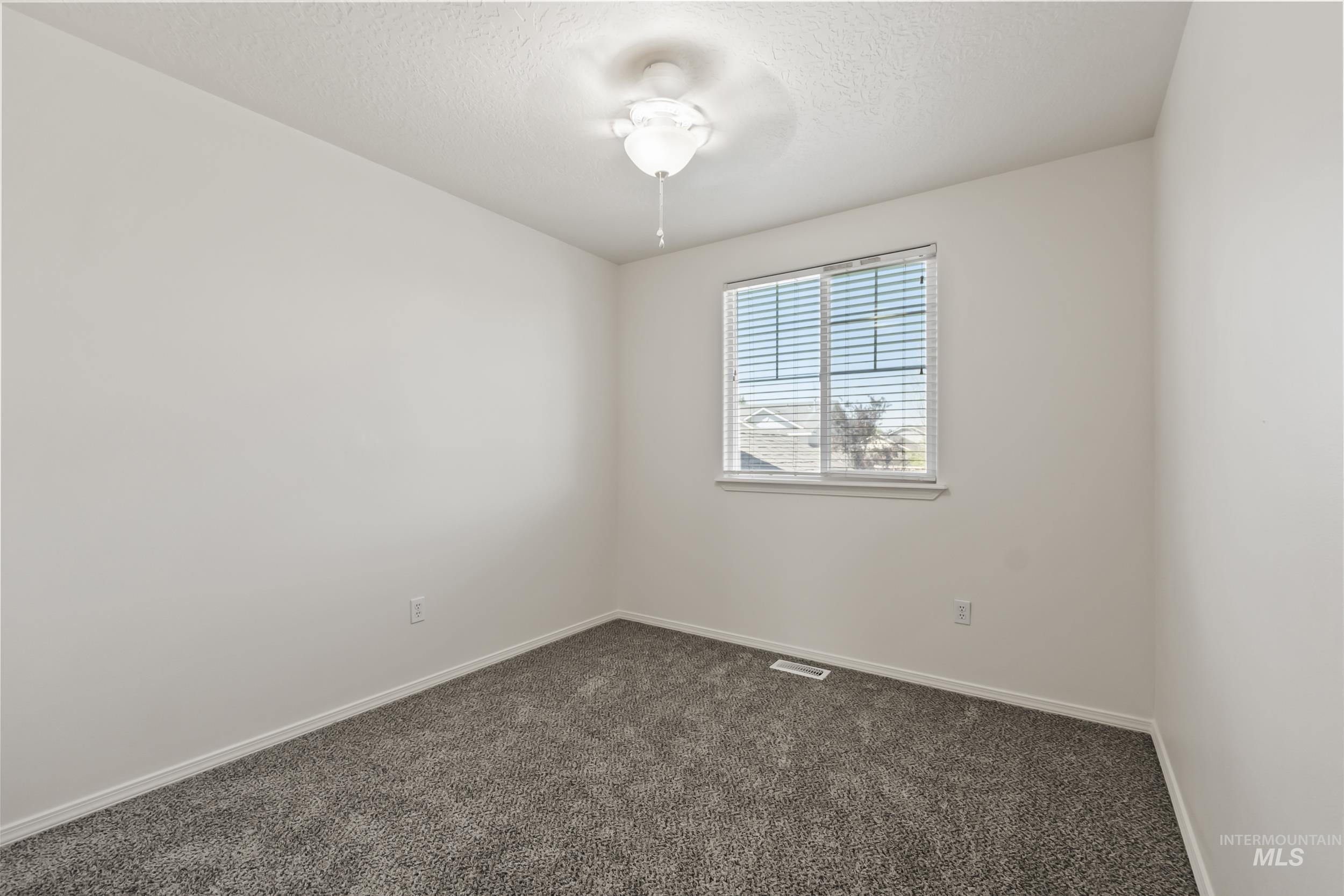 Unfurnished room featuring carpet and a textured ceiling