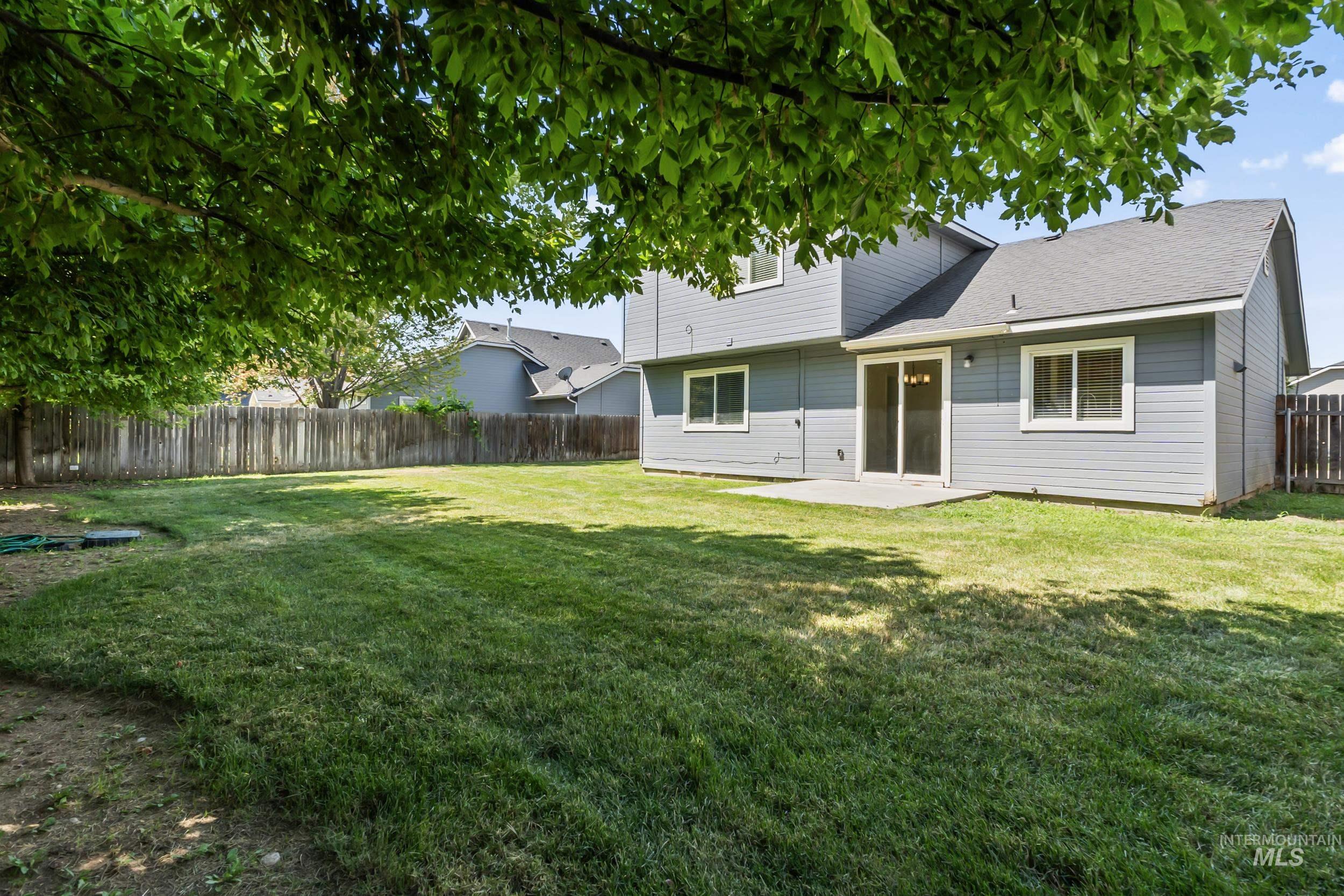 Back of house with a patio, a fenced backyard, and roof with shingles
