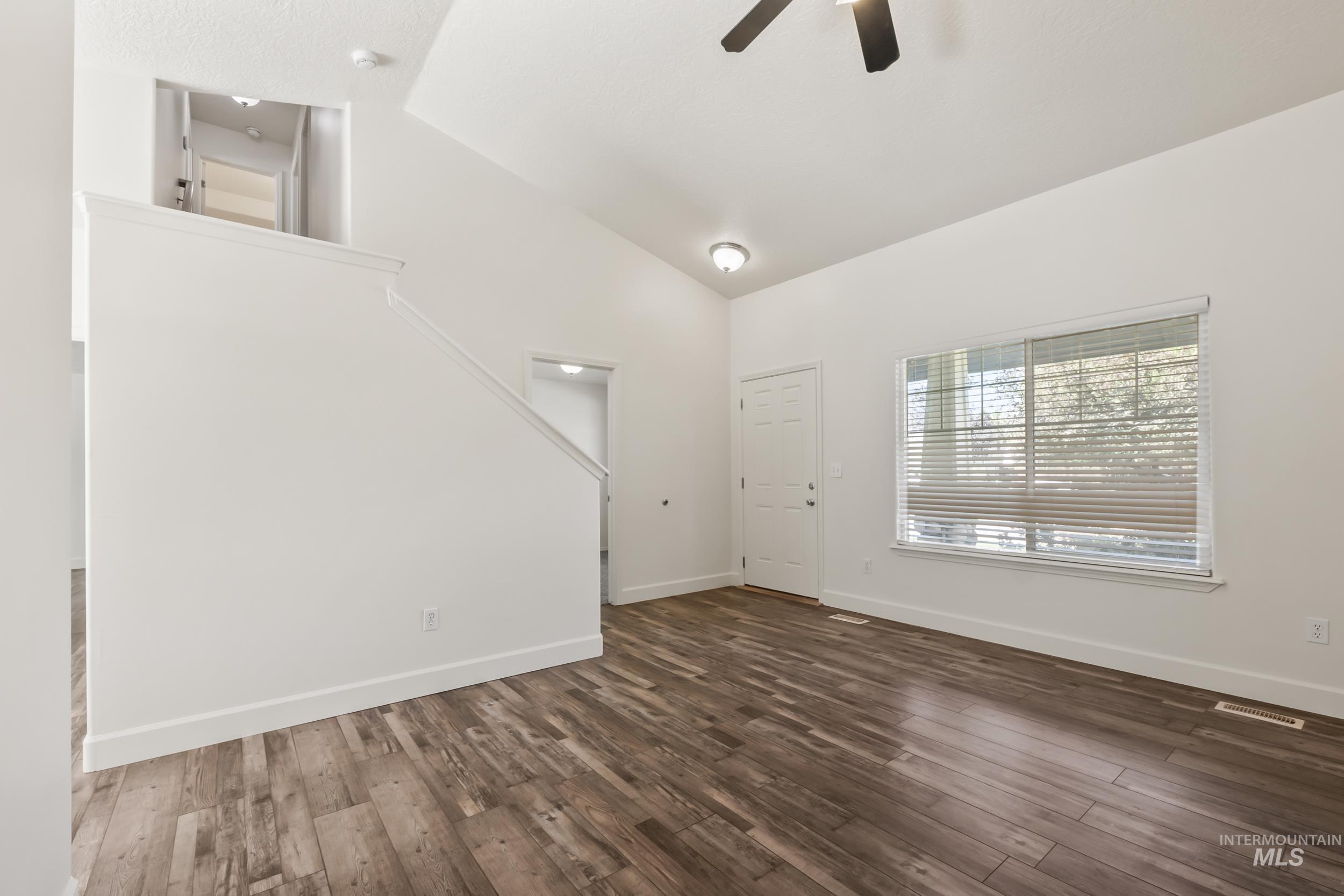 Entryway featuring dark wood finished floors, a ceiling fan, and high vaulted ceiling