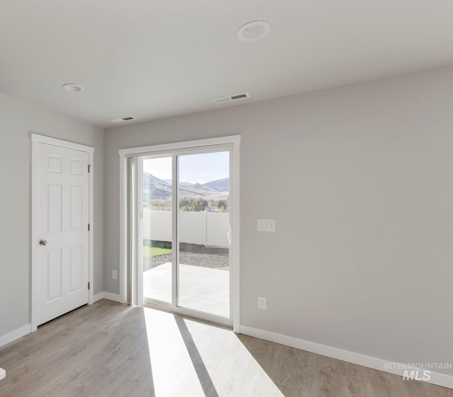 Kitchen featuring stainless steel fridge with ice dispenser, light wood finished floors, hanging light fixtures, a mountain view, and recessed lighting
