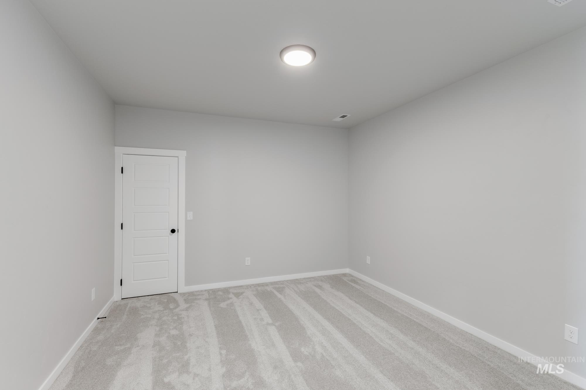 Carpeted spare room with baseboards