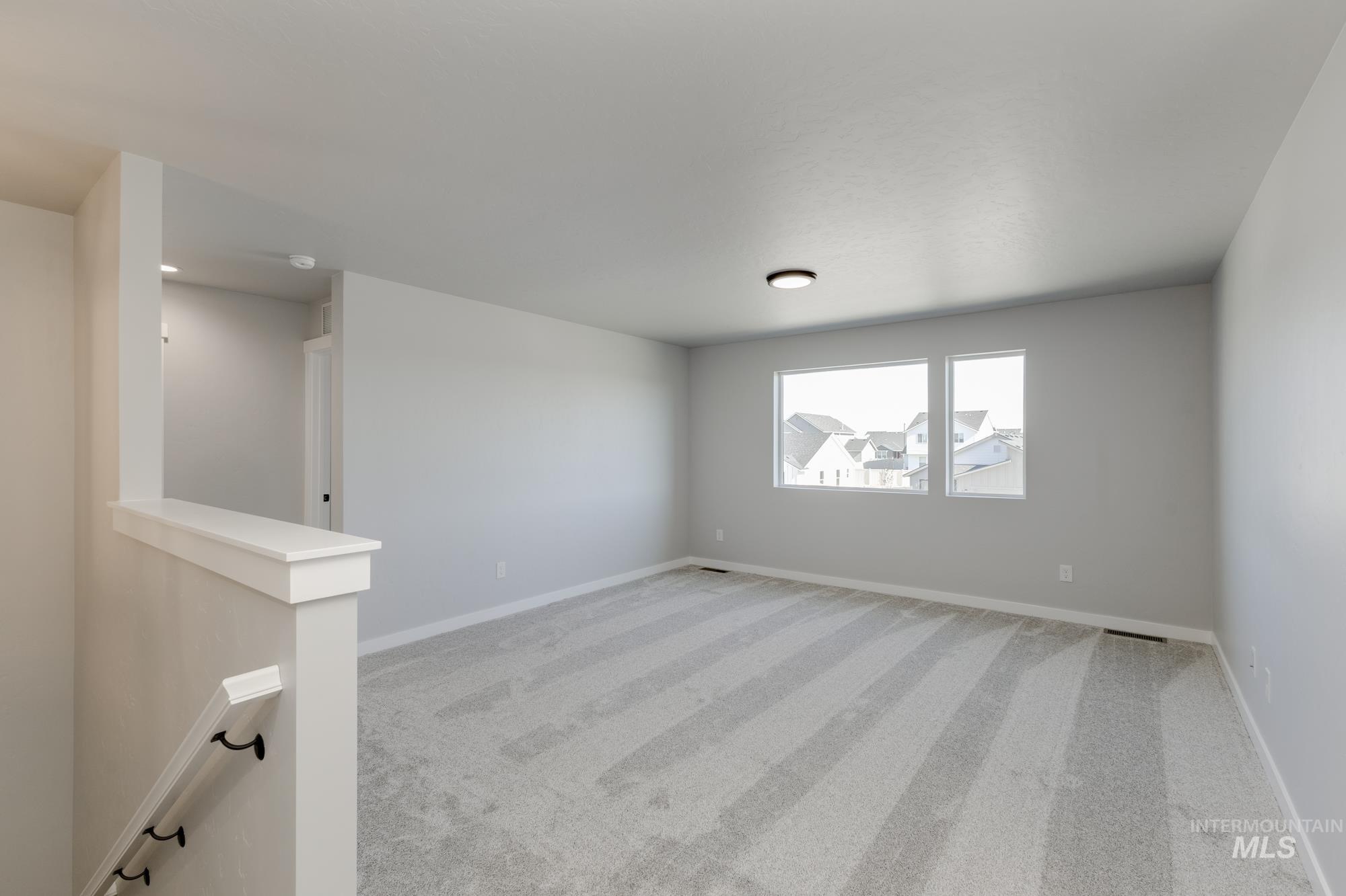 Unfurnished room with light carpet and baseboards