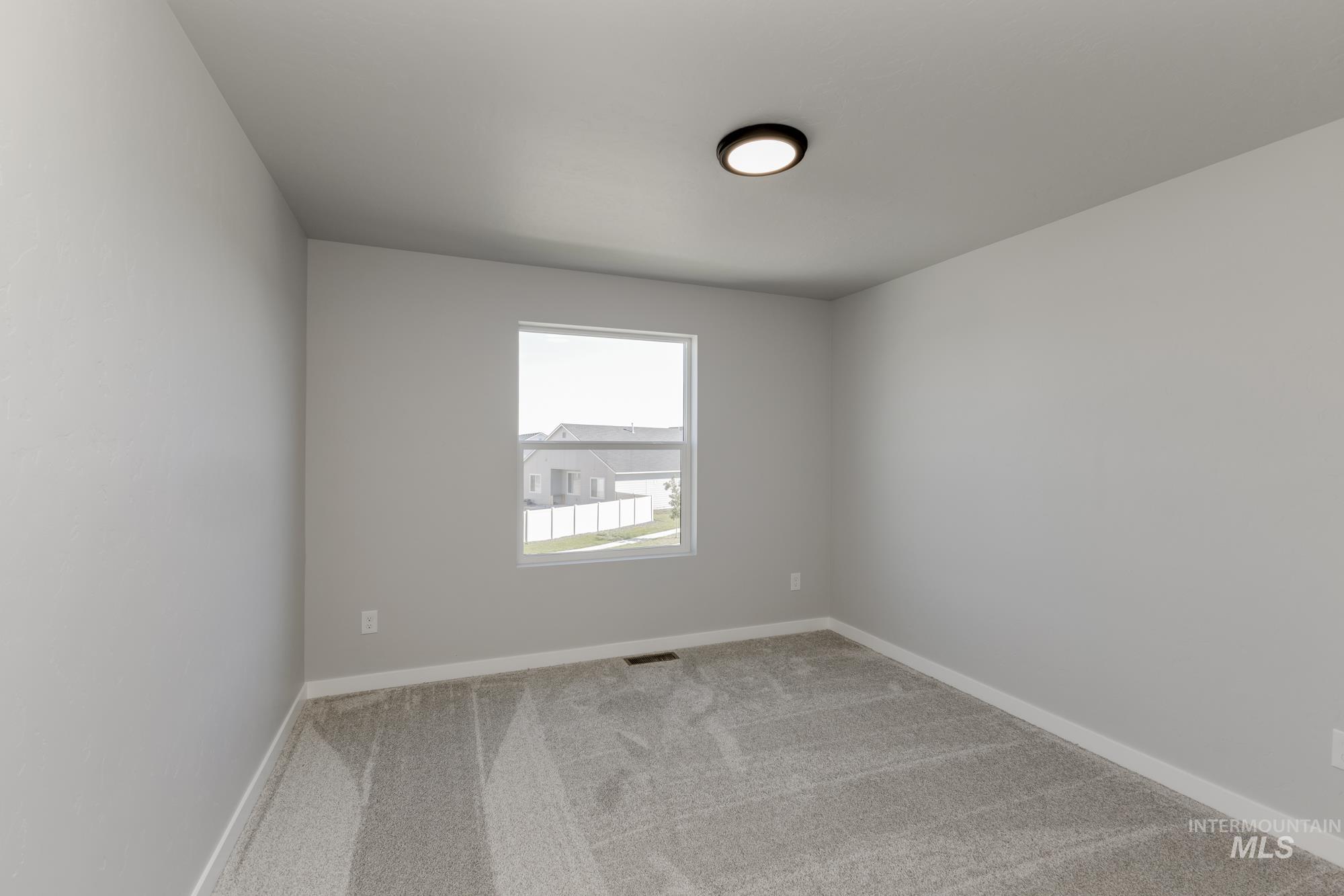 Carpeted empty room featuring baseboards